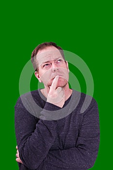 Middle aged man in deep thought looking up captured on green screen background