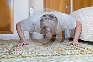 Middle-aged man doing push-ups at home