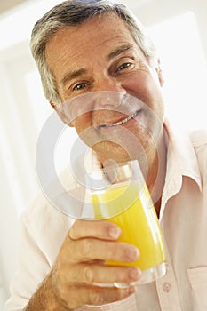 Middle Aged Man Drinking A Glass Of Orange Juice