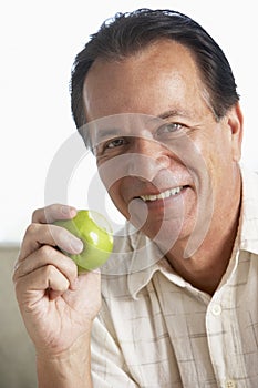 Middle Aged Man Eating Green Apple And Smiling