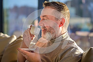 Middle-aged man enjoying a cup of aromatic coffee