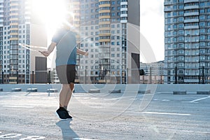 Middle-aged man exercising with jump-rope outdoors.