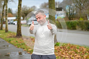 Middle-aged man giving a double thumbs up if success and support