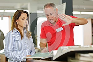 Middle aged man giving instructions to female colleague