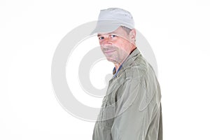 Middle aged man in green shirt and cap smiling profile side view over white background and looking camera