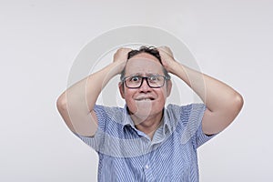 A middle aged man having a mental breakdown after being overwhelmed by personal and financial stress. Grabbing his hear. Isolated