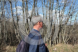 Middle-aged man hiking through the nature in a spring time