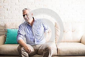 Middle aged man at home suffering from back pain