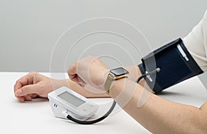 Middle-aged man inputting blood pressure on smartwatch. Digital Healthcare Concept