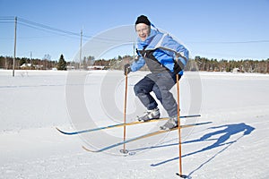 Middle-aged man jumping in the air with skis