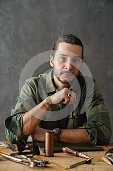 Middle aged man leathersmith working at his workshop
