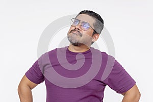 A middle aged man looking confounded and stumped, looking for questions. Wearing eyeglasses and a purple waffle shirt, Isolated on photo