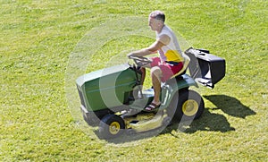 Middle-Aged Man Mowing lawn on riding mower