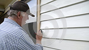 Middle-aged Man Painting Weatherboards.