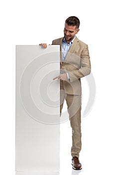 Middle aged man pointing finger and showing empty board