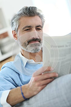 Middle-aged man reading newspaper