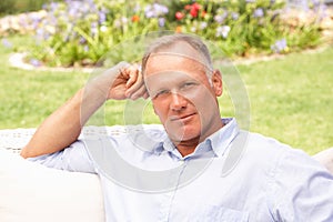 Middle Aged Man Relaxing In Garden