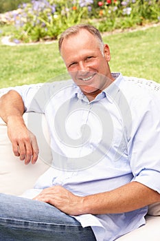 Middle Aged Man Relaxing In Garden