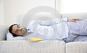 Middle aged man resting on his sofa