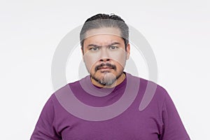 A middle aged man seems to be insulted by offensive remarks. Looking at the camera and seething in anger. Isolated on a white photo