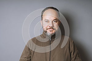 Middle aged man with short dark hair and graying beard smiling