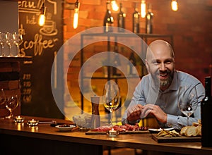 Middle-aged man sitting behind bar counter