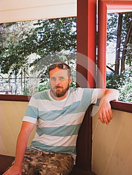 A middle aged man sitting on a rotunda bench