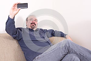 Middle-aged man sitting and taking selfie pictures