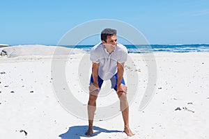 Middle aged man standing in shorts at the beach