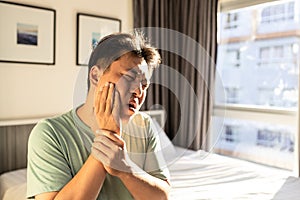 Middle aged man suffer Trigeminal neuralgia,touch his cheek with hand,severe pain of a nerve in face,painful in bulge of cheek and