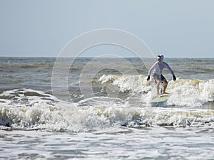 Middle aged man surfing a long board on the Atlatic Ocean in South Carolina