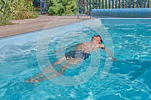 A man swims in a pool in the courtyard