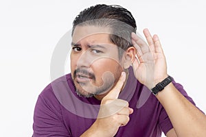 A middle aged man telling someone to speak loude. Gesturing with his hand on his ear, pointing with his finger. Having trouble