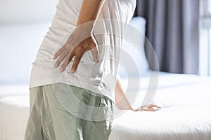 Middle aged man touching his hip,backache while standing or walking,symptom of chronic muscle injury,Stressed asian people