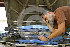 Middle-aged man trying to repair their own cars.