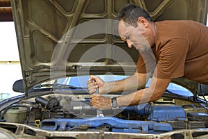 Middle-aged man trying to repair their own cars.