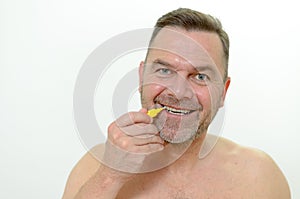 Middle aged man using interdental brush