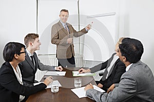 Middle-aged man using whiteboard in business meeting