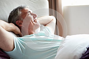 Medio vecchio uomo veglia su un letto 