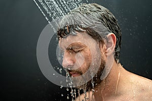 Middle aged man washing hair in bath. Guy bathing shower head in bathtub. Face in foam in shower. Bathing man taking
