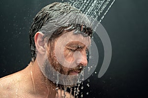 Middle aged man washing hair in bath. Guy bathing shower head in bathtub. Face in foam in shower. Bathing man taking