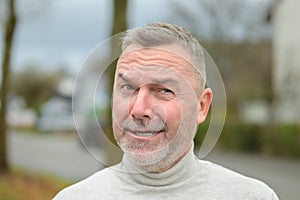 Middle-aged man winking at camera with a cheesy grin