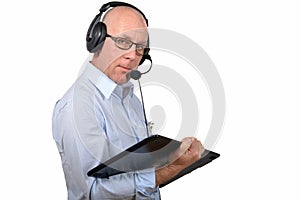 A middle-aged man working with a digital tablet and headphones