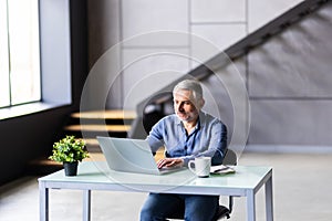 Middle-aged man working from home office on laptop