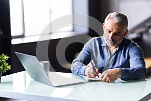 Middle-aged man working from home office on laptop