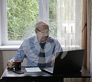 middle-aged man works on laptop at home, hostility of emotions