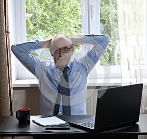 Middle-aged man works on laptop at home, hostility of emotions