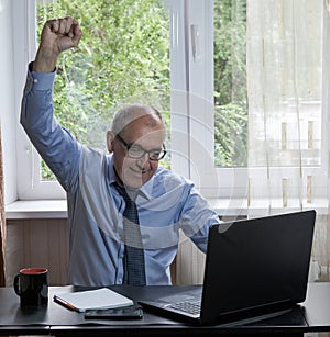 Middle-aged man works on laptop at home, hostility of emotions