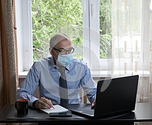 Middle-aged man works on laptop at home, hostility of emotions