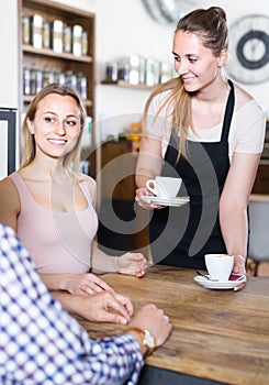 Middle aged man and young woman talking in cozy cafe